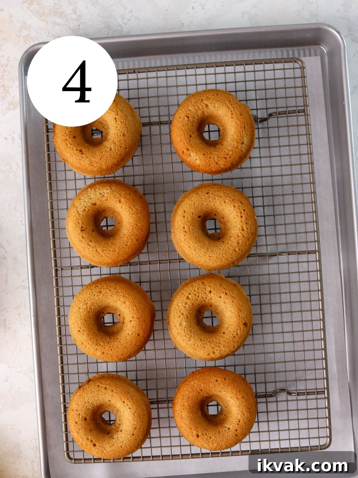 Irresistible Peanut Butter Donuts Recipe — Soft, Gooey, Homemade 7 Eight baked donuts on a wire rack set on a baking sheet.