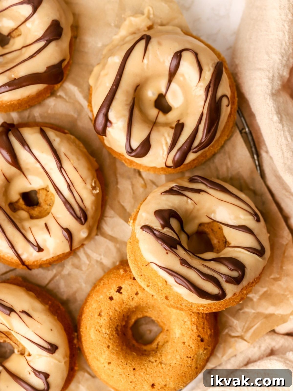 Irresistible Peanut Butter Donuts Recipe — Soft, Gooey, Homemade 10 A batch of peanut butter donuts with a peanut butter glaze and drizzled with chocolate.