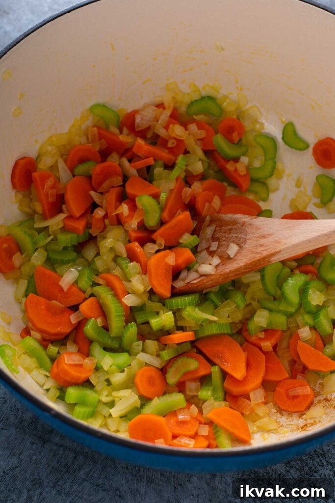 Sautéing chopped onion, carrots and celery in olive oil in a Dutch oven