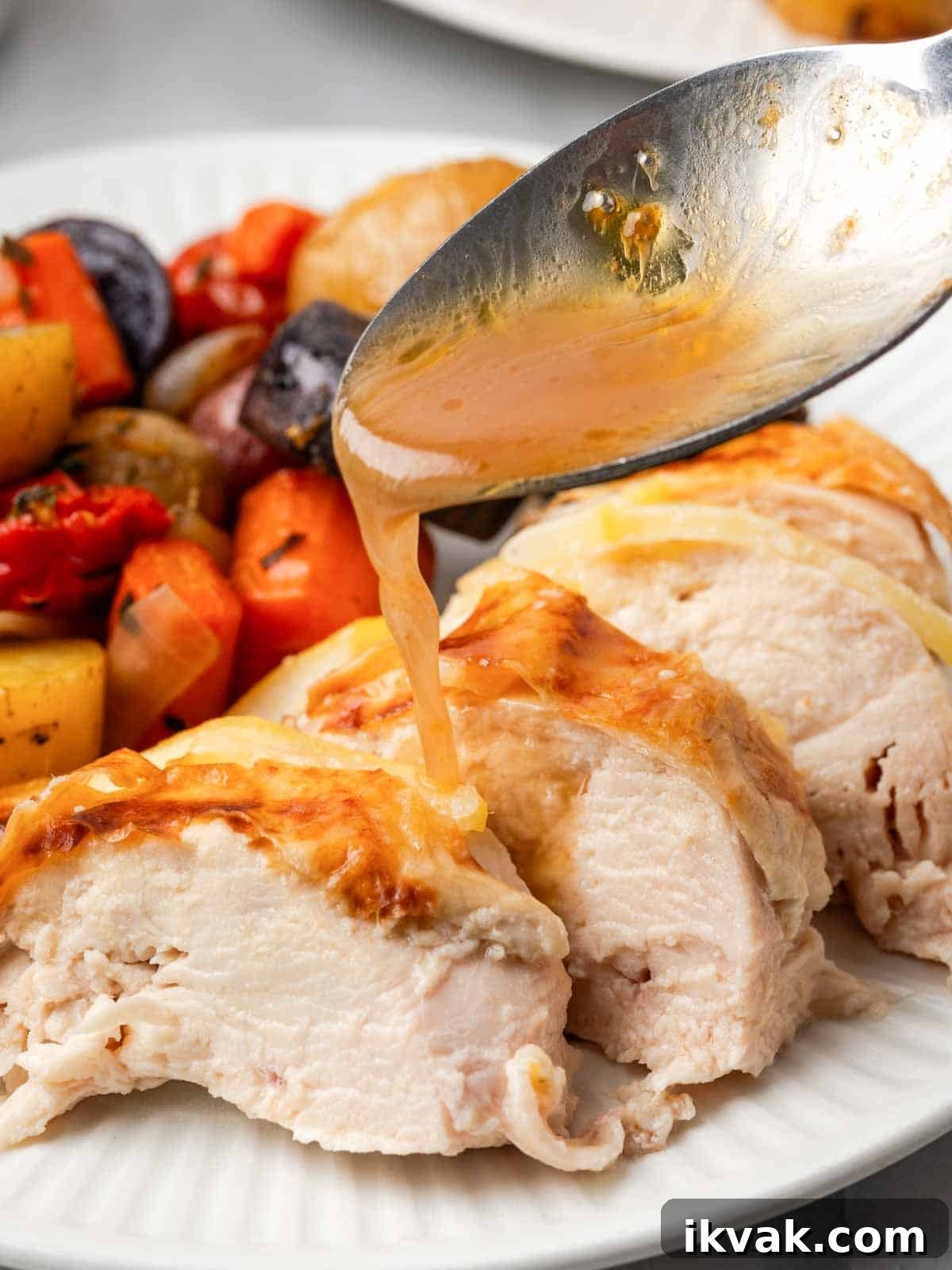 adding pan sauce to sliced chicken.