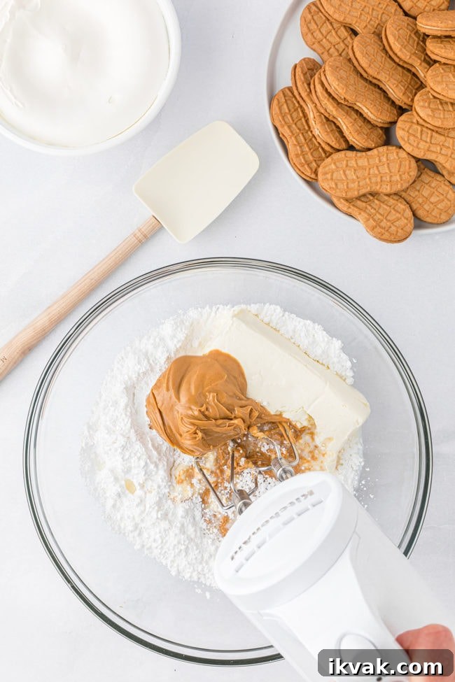 Mixing cream cheese, powdered sugar and peanut butter in a glass bowl step 1