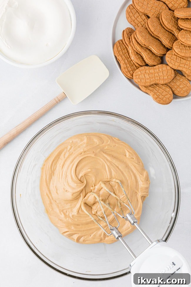 mixing peanut butter fluff layer for icebox cake in a glass bowl - step 2