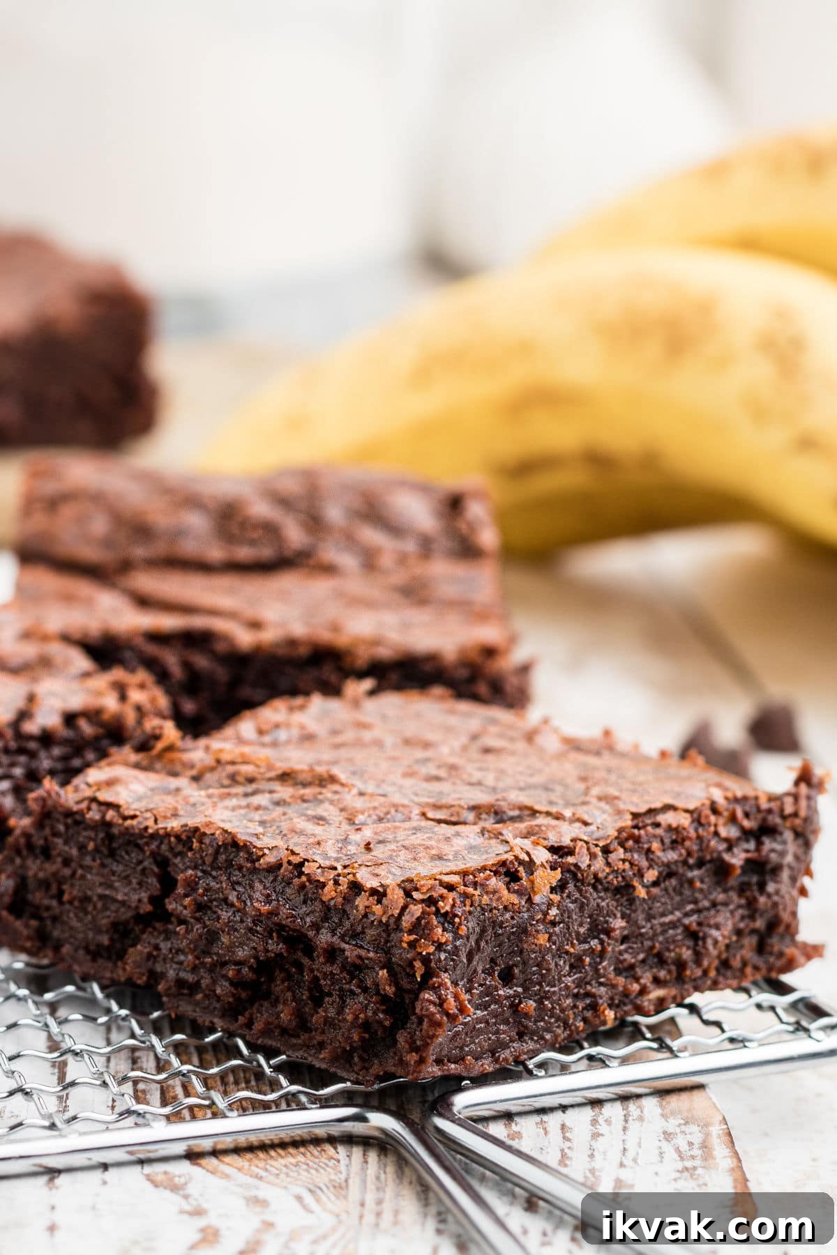 a close up of a banana brownie with bananas in the background