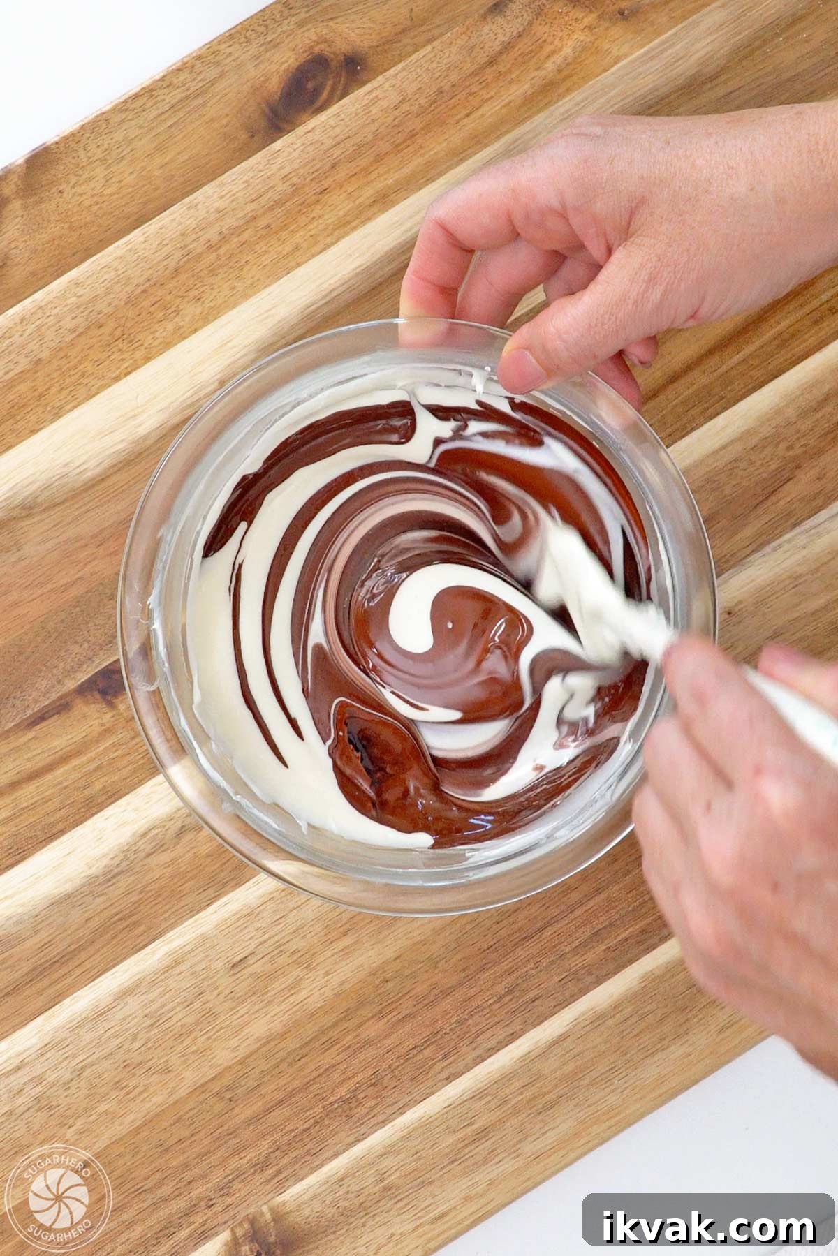 Stirring brown coloring into a bowl of melted white candy coating.
