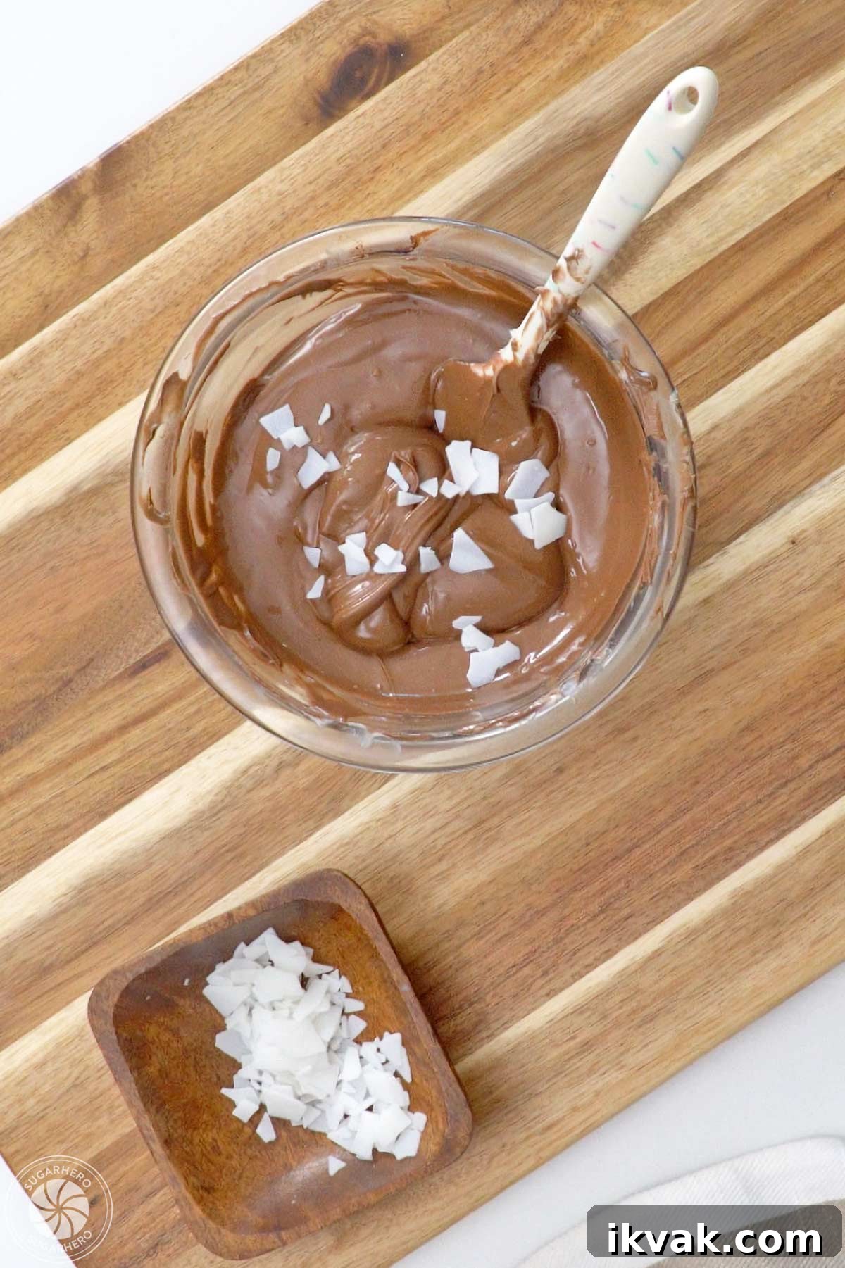 Flakes of paramount crystals on top of a bowl of brown candy coating.