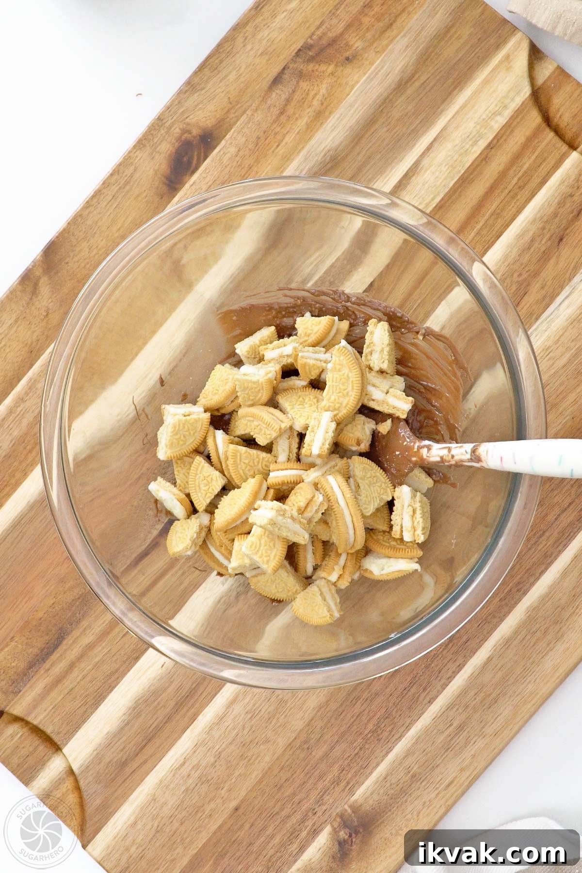 Chopped cookies on top of melted coating and popping candy in a glass bowl.