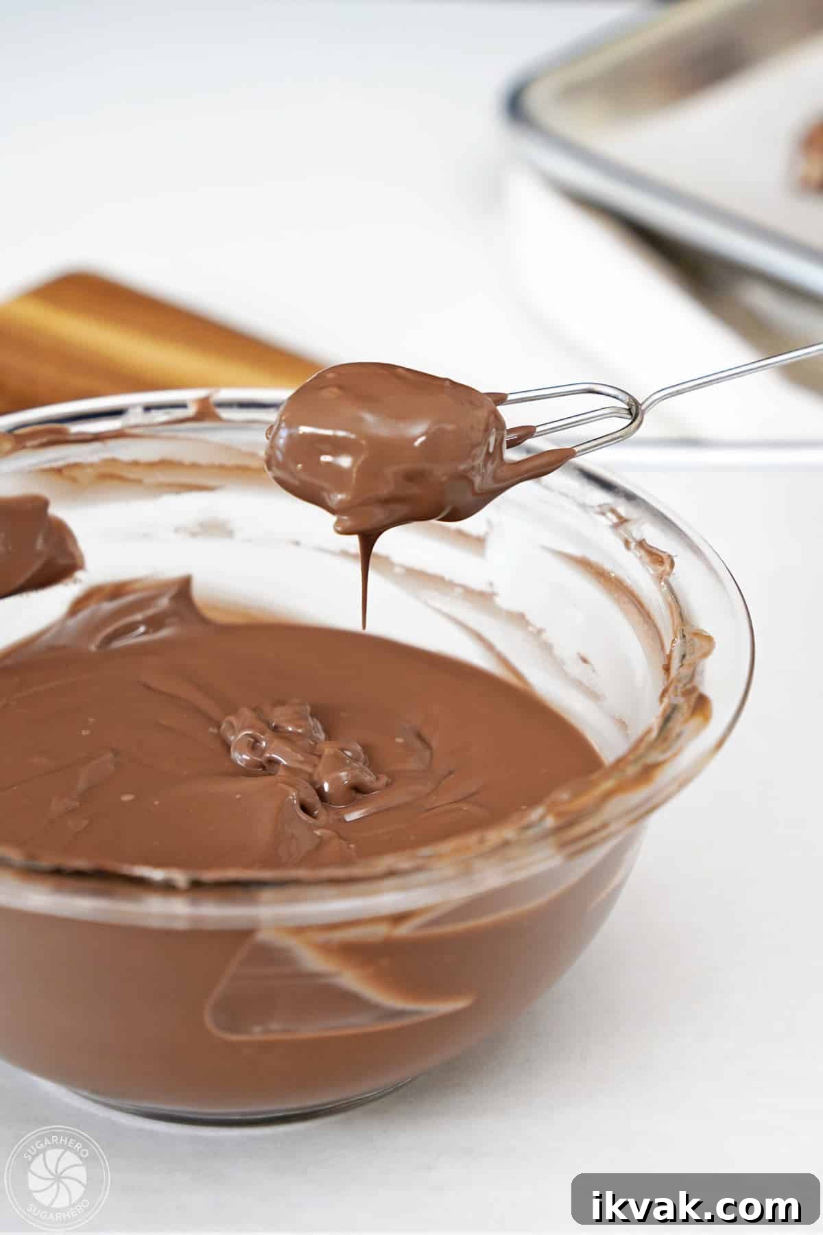 Dipping a Root Beer Float piece in melted candy coating.