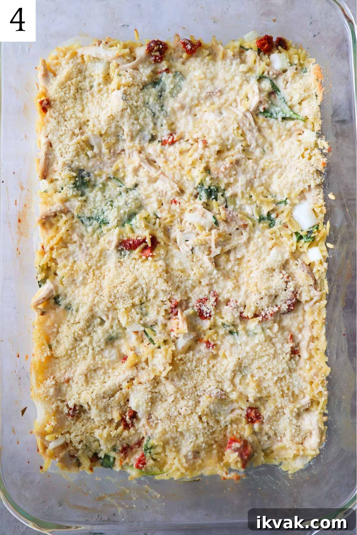 glass baking dish with orzo topped with parmesan cheese.