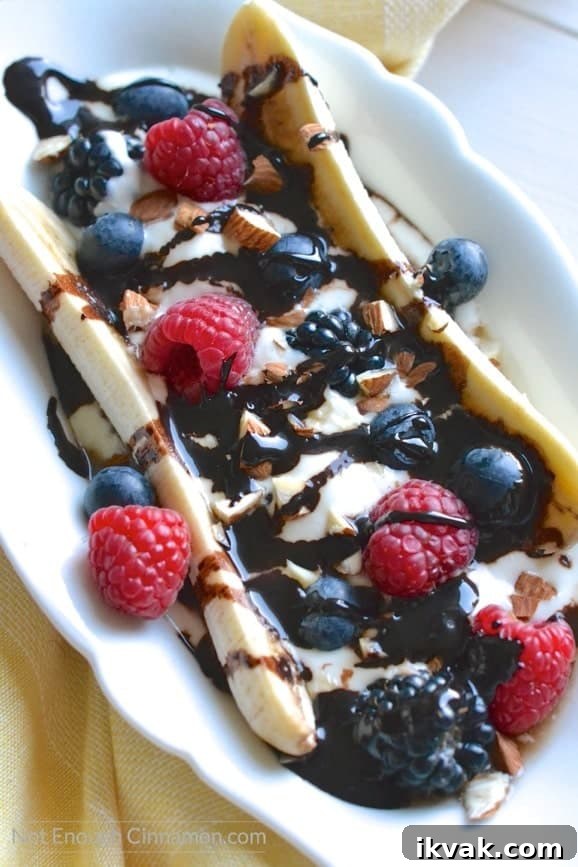 overhead shot of healthy banana split filled with berries and drizzled with clean eating sugar-free chocolate sauce