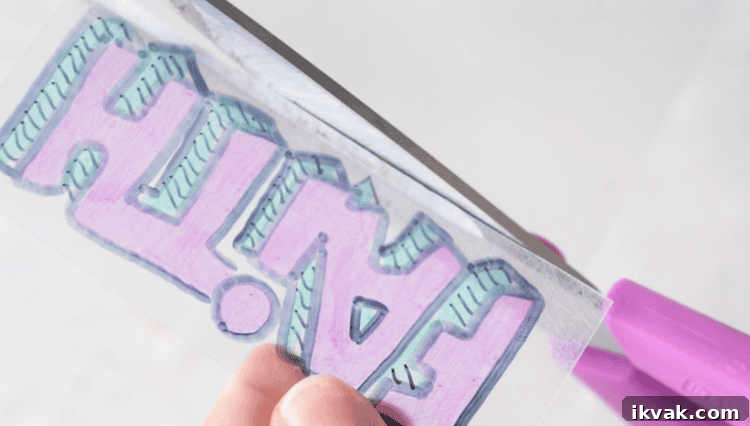 scissors cutting around edge of YW camp shrinky dink