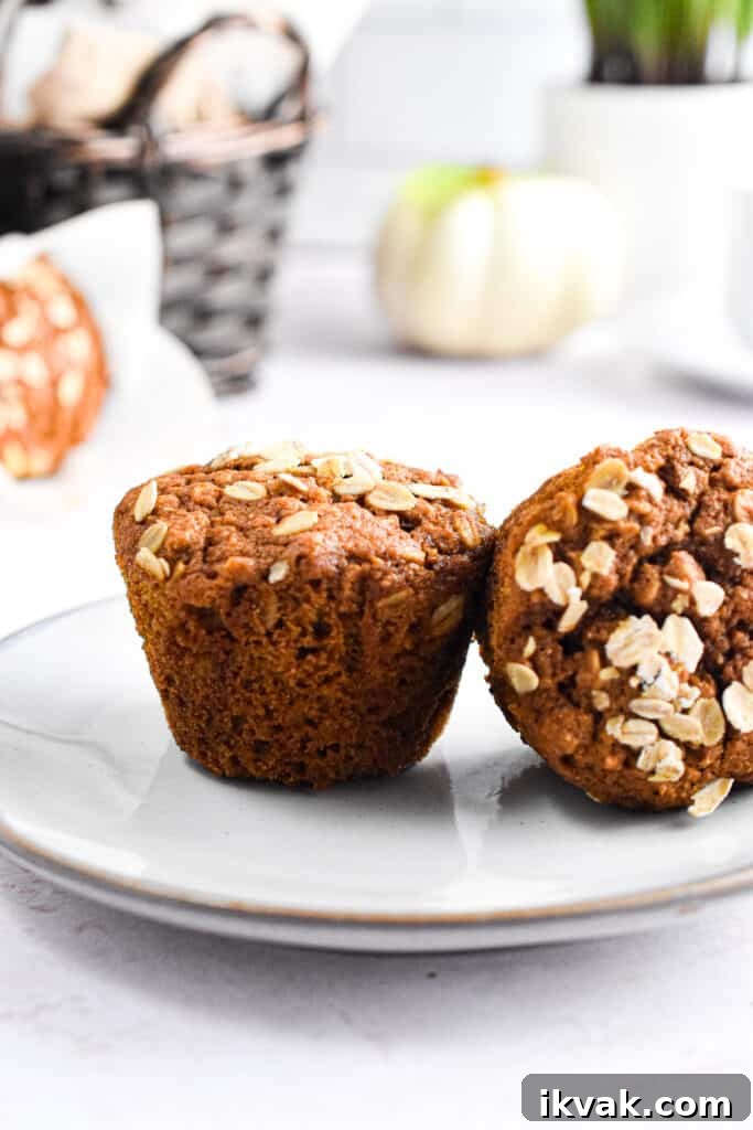 Pumpkin Oatmeal Muffins with Warm Spices and Maple Glaze 15 Two pumpkin oatmeal muffins are on a plate.