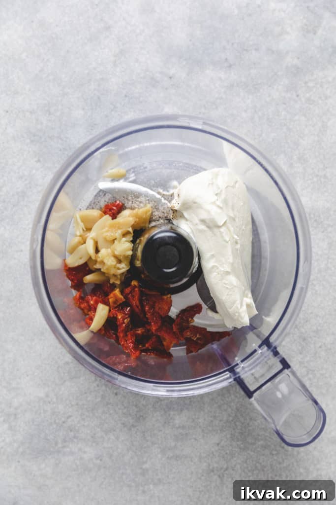 Cream cheese, garlic, and sun-dried tomatoes in a food processor.