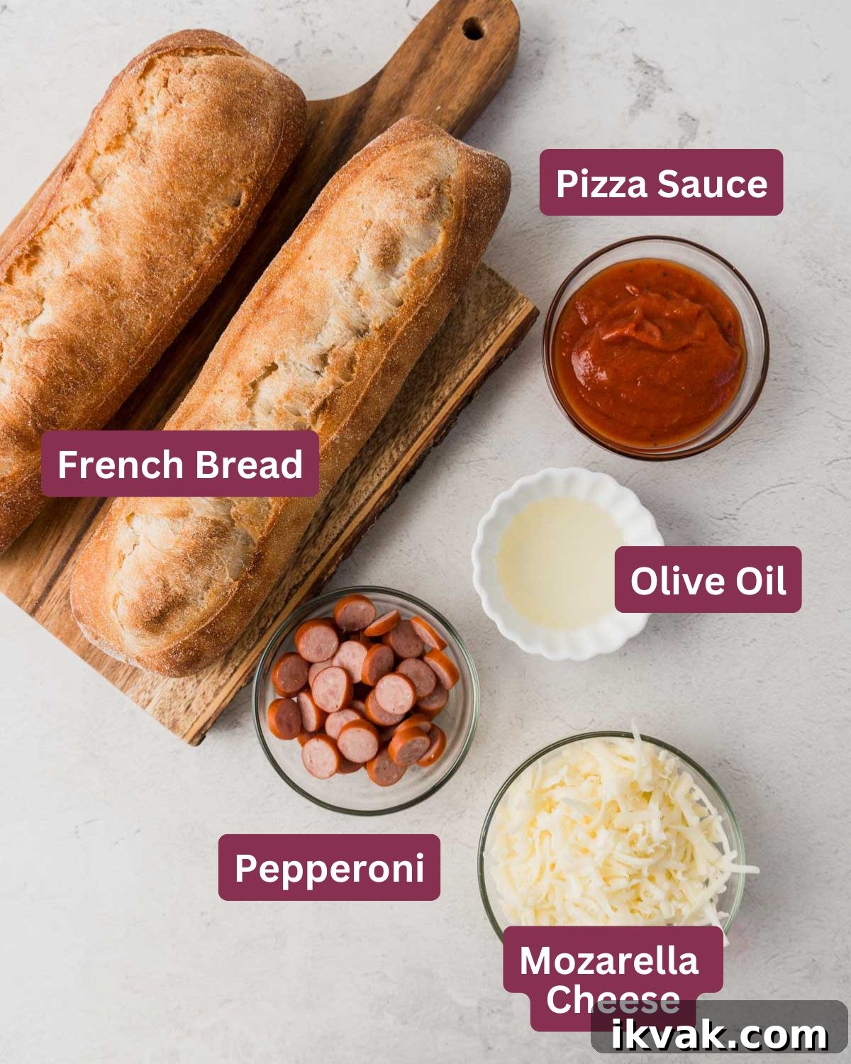 French bread pizza ingredients including french bread, pizza sauce, olive oil, pepperoni, and mozarella cheese on white background.
