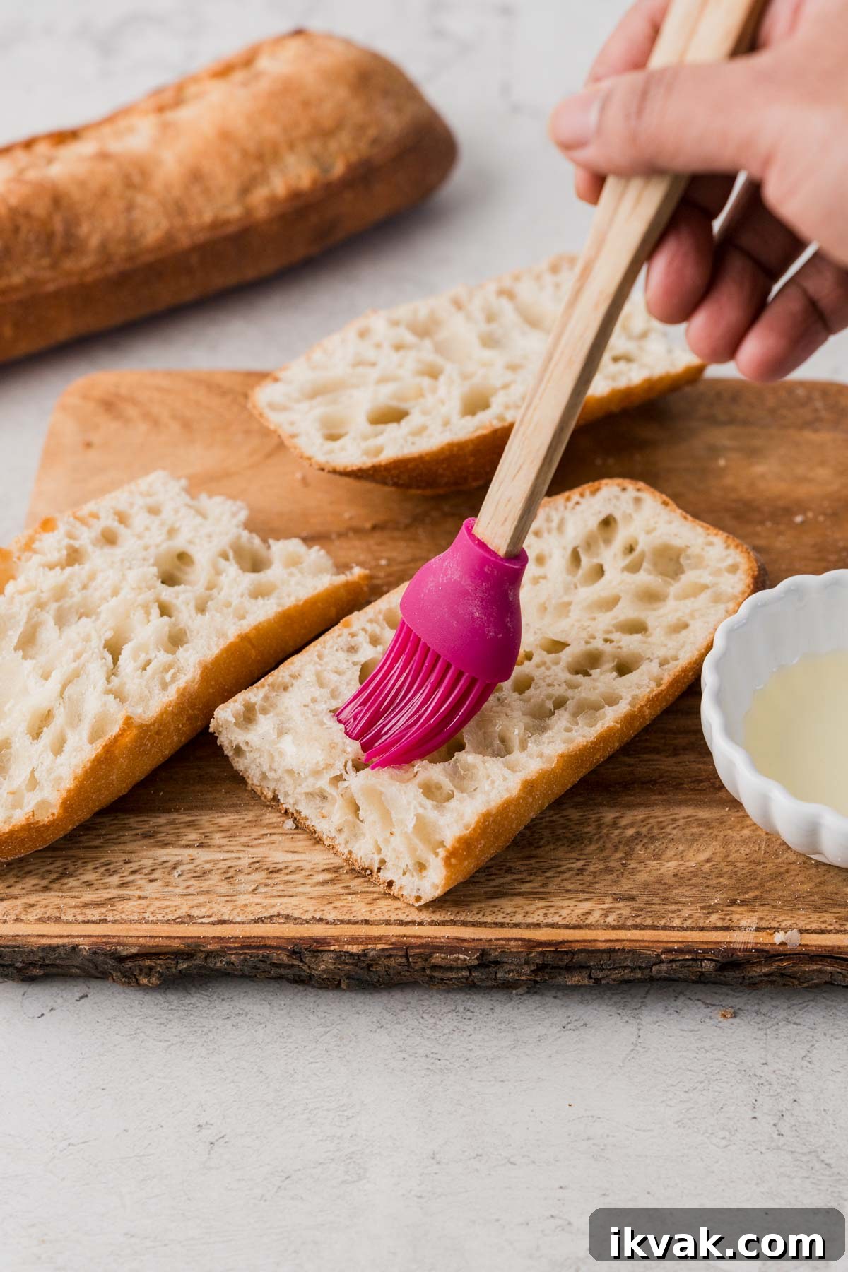 brushing oil on french bread.