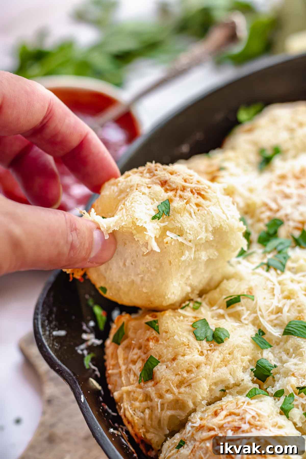 A hand pull a bread bite out of the pan.