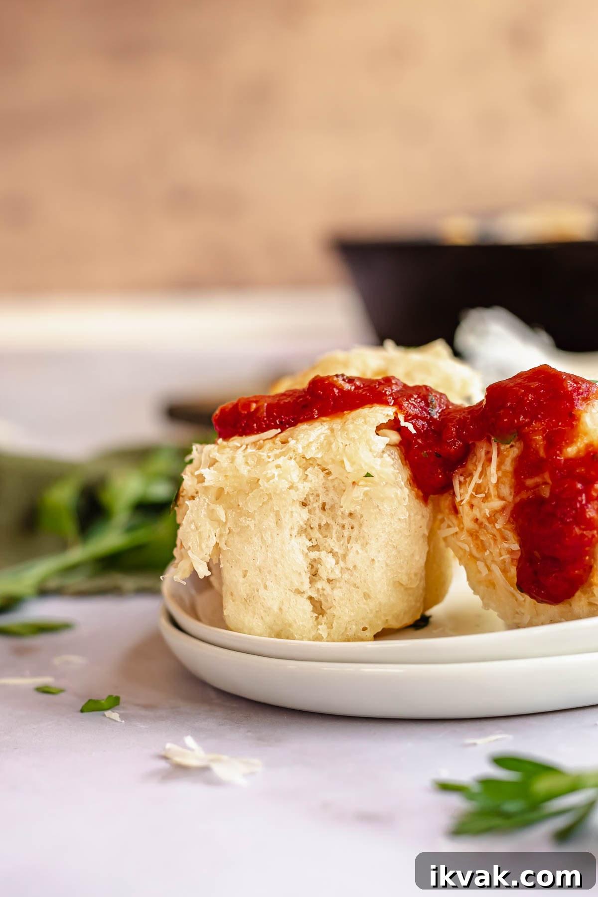 Bread bites on a plate with marinara sauce on top.