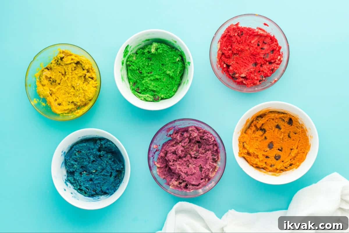 Bowls of chocolate chip cookie dough dyed a range of rainbow colors.