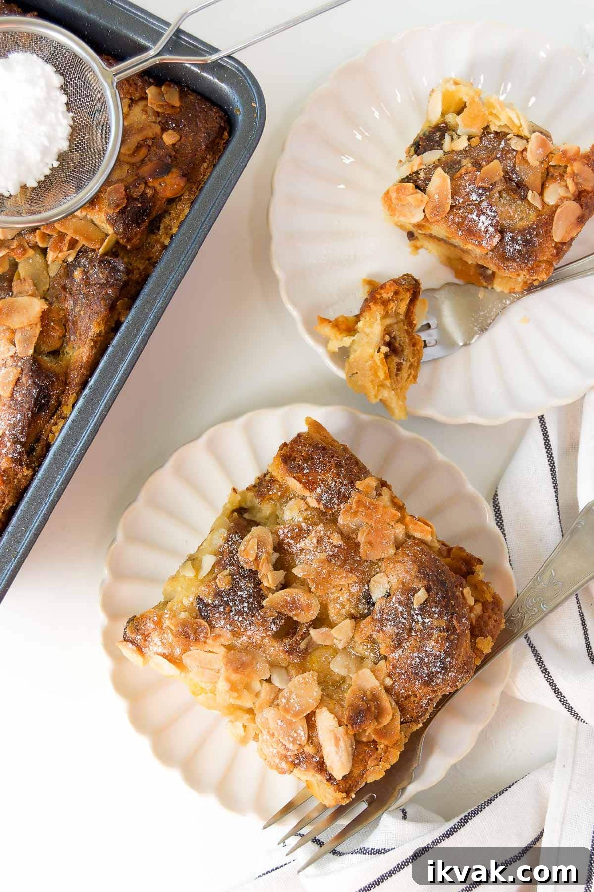 Decadent Panettone Bread Pudding Recipe for Holiday Brunch 8 two slices of panettone bread pudding on scalloped plates next to a baking dish
