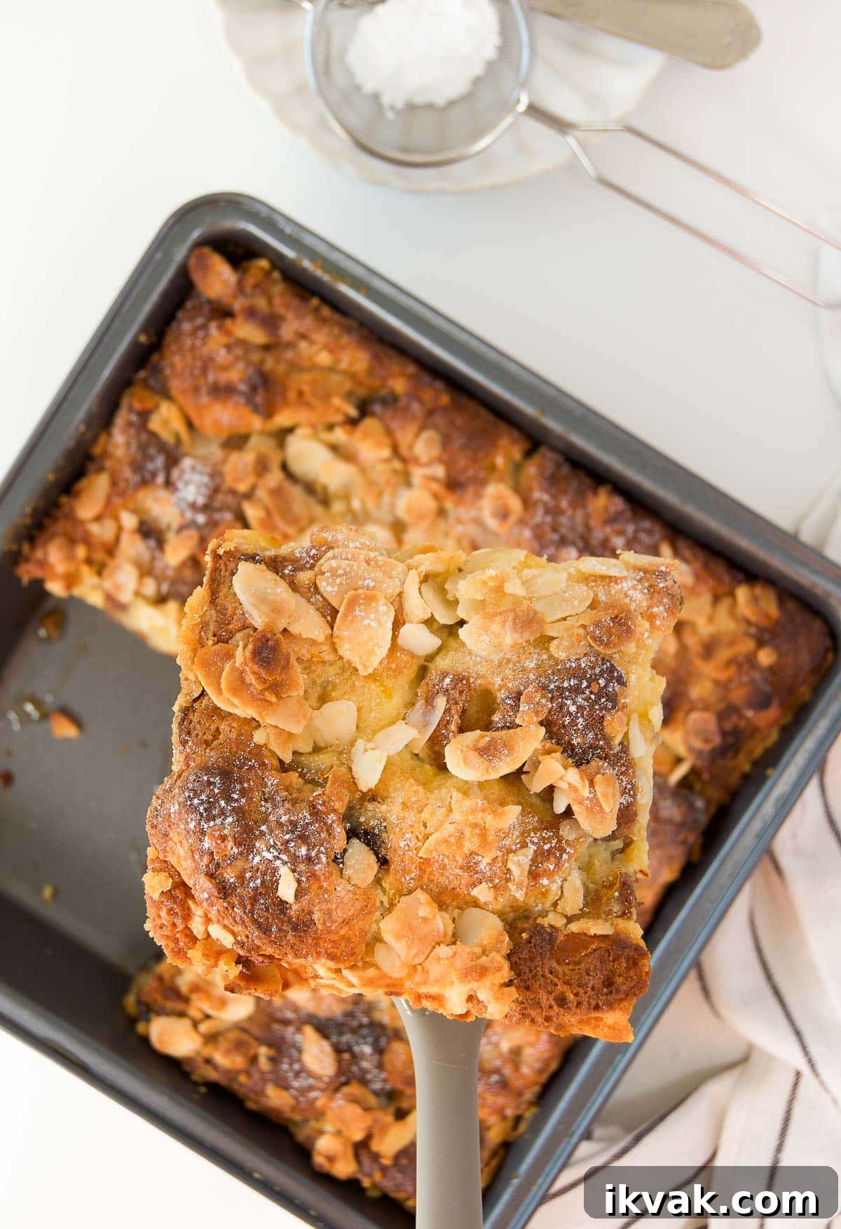 Decadent Panettone Bread Pudding Recipe for Holiday Brunch 3 a spatula lifts a slice of panettone bread pudding out of a pan