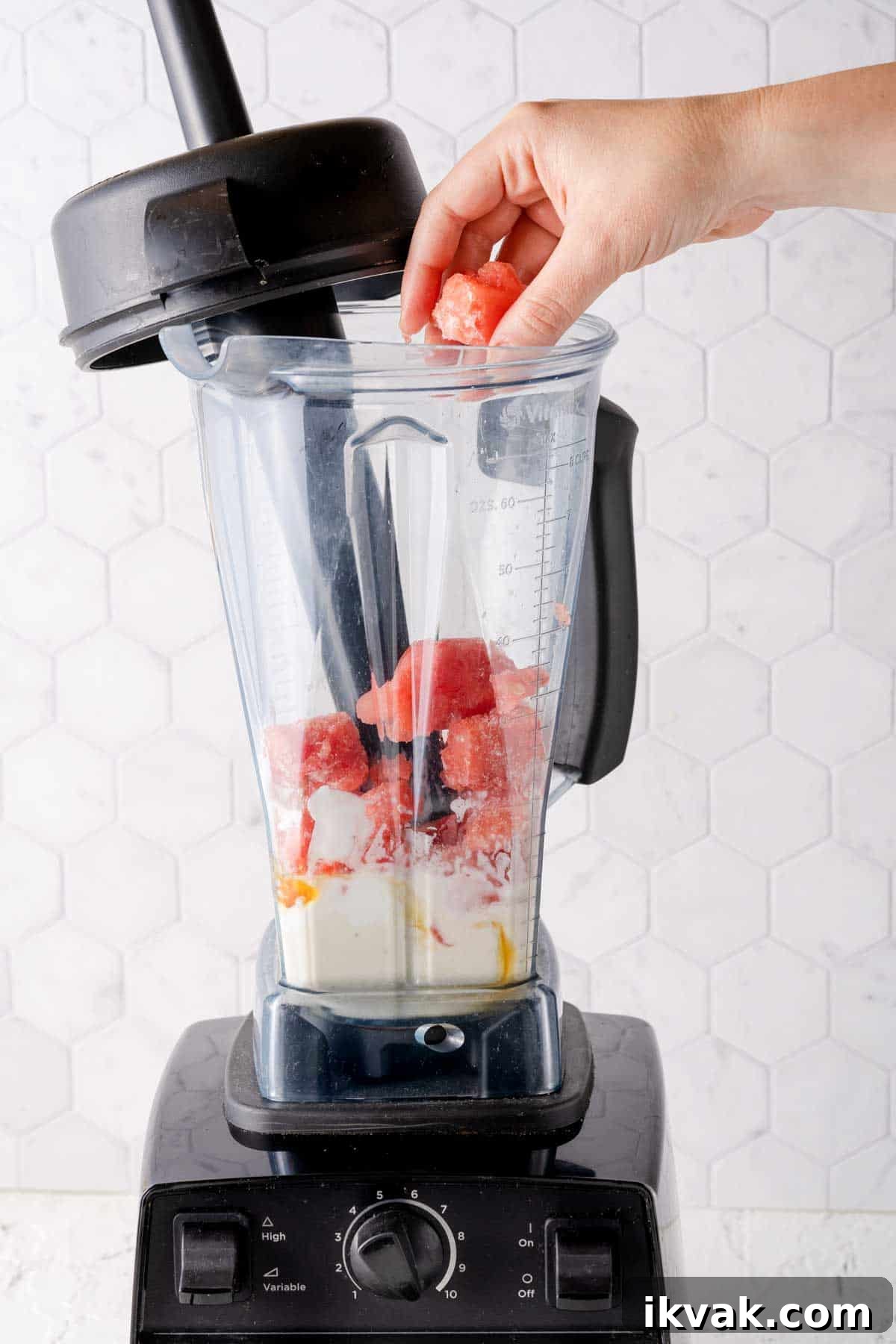 Creamy Banana and Watermelon Smoothie Recipe 6 chunks of frozen watermelon being added to blender with other smoothie ingredients inside