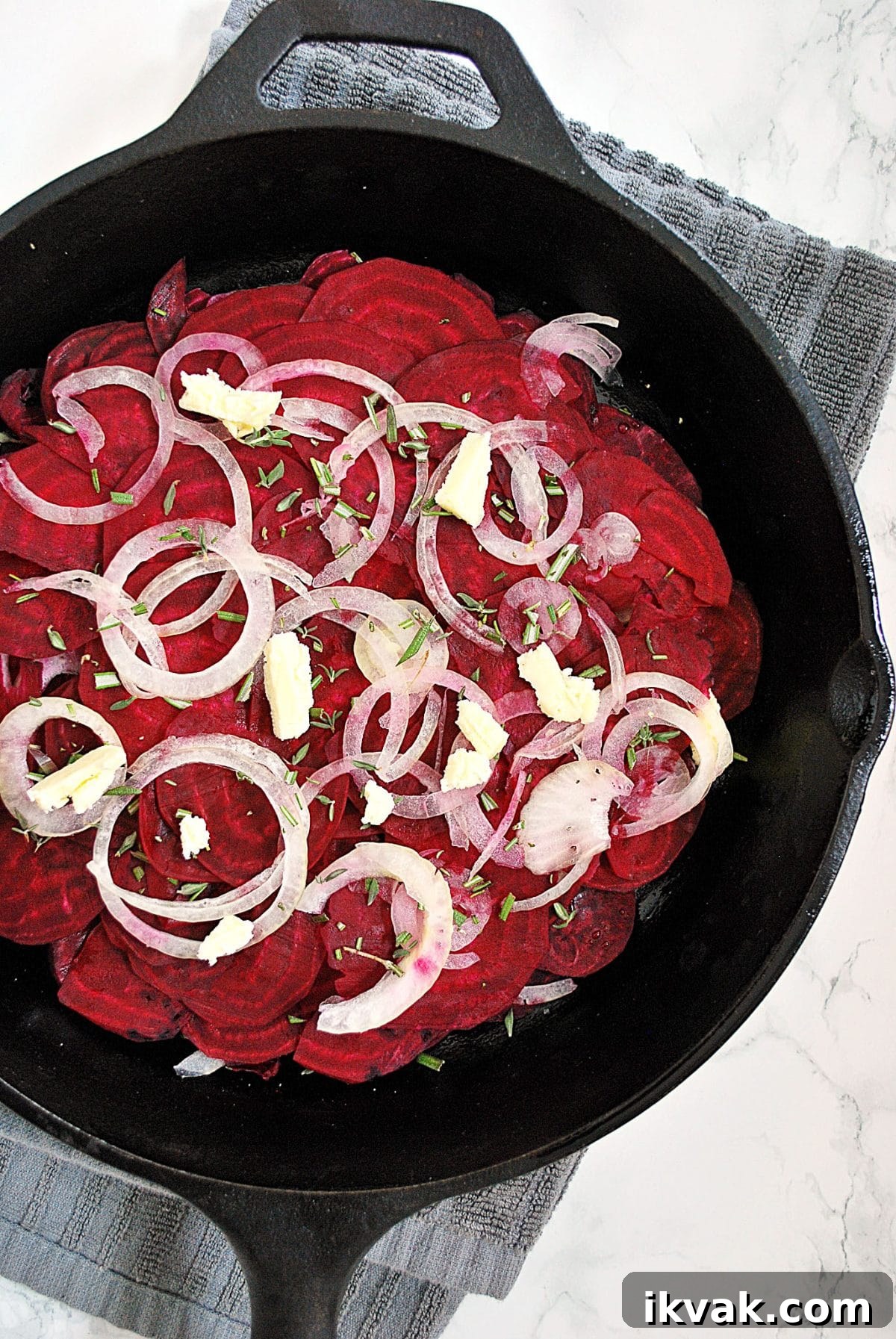 Potato and Beetroot Boulangère Recipe for Crispy Layered Potatoes 3 Thinly sliced beets placed into a cast iron skillet and topped with onions, butter and herbs.