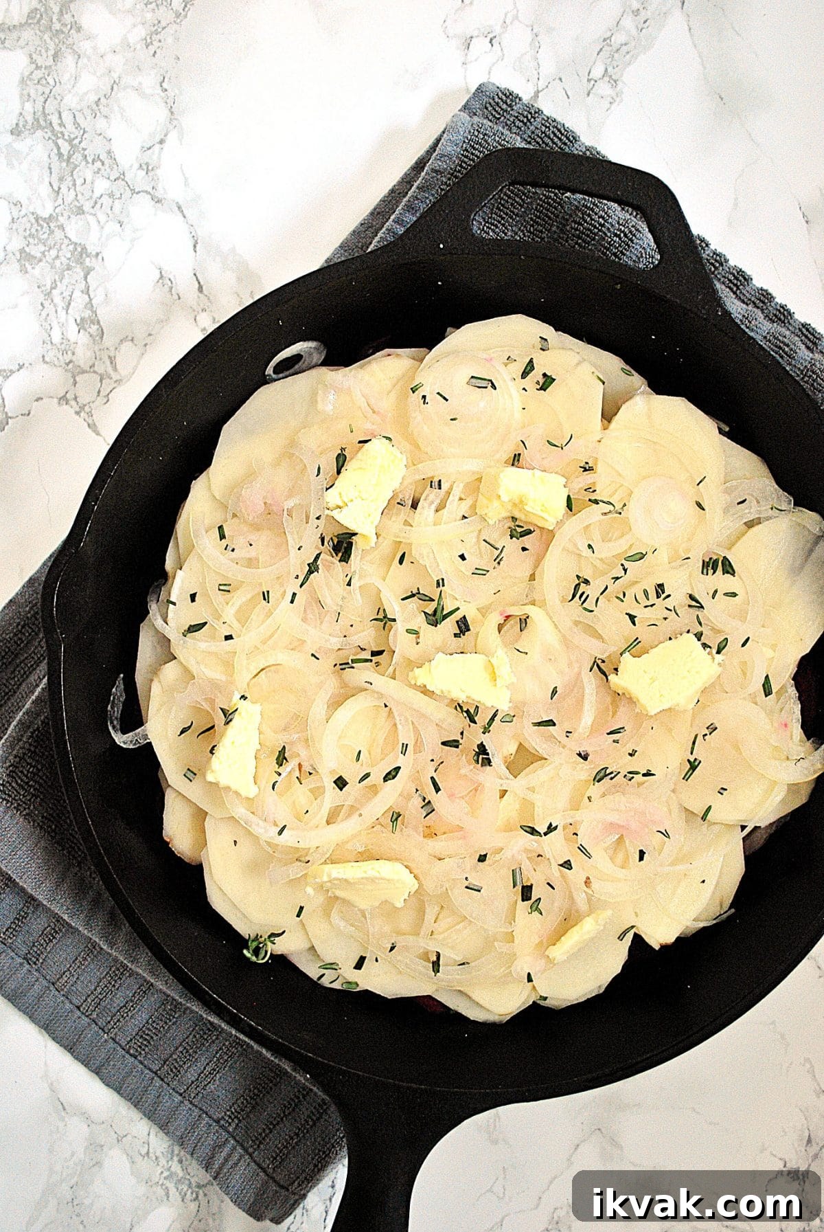 Potato and Beetroot Boulangère Recipe for Crispy Layered Potatoes 4 A cast iron skillet layered with thinly sliced beet and thinly sliced potatoes.