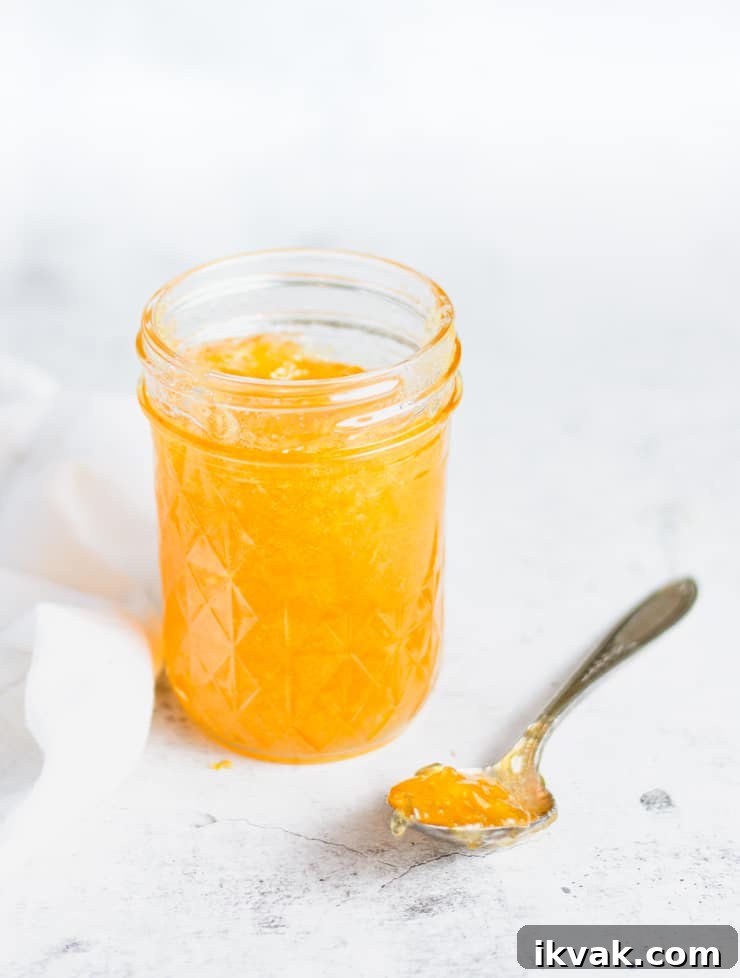 Small-Batch Bourbon Peach Jam Recipe for Preserving Summer Flavor 2 open jar of jam with a spoonful next to it