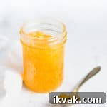 open jar of jam with a spoonful next to it