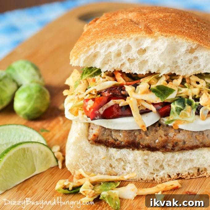Close up shot of sausage mozzarella sandwich with chipotle lime slaw on a wooden cutting board.