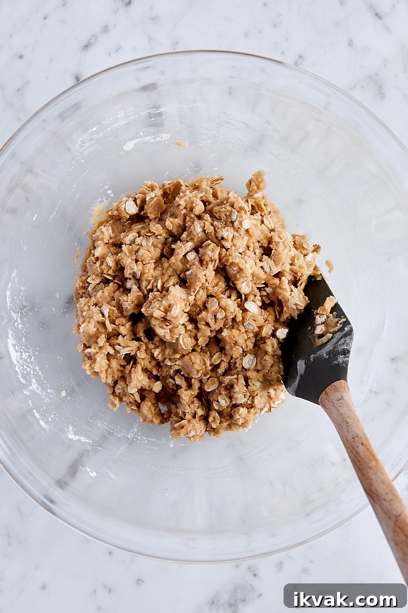 Chewy Raspberry Crumble Bars with Oat Crust 9 Crust and crumble dough mixed together in large glass bowl with spatula