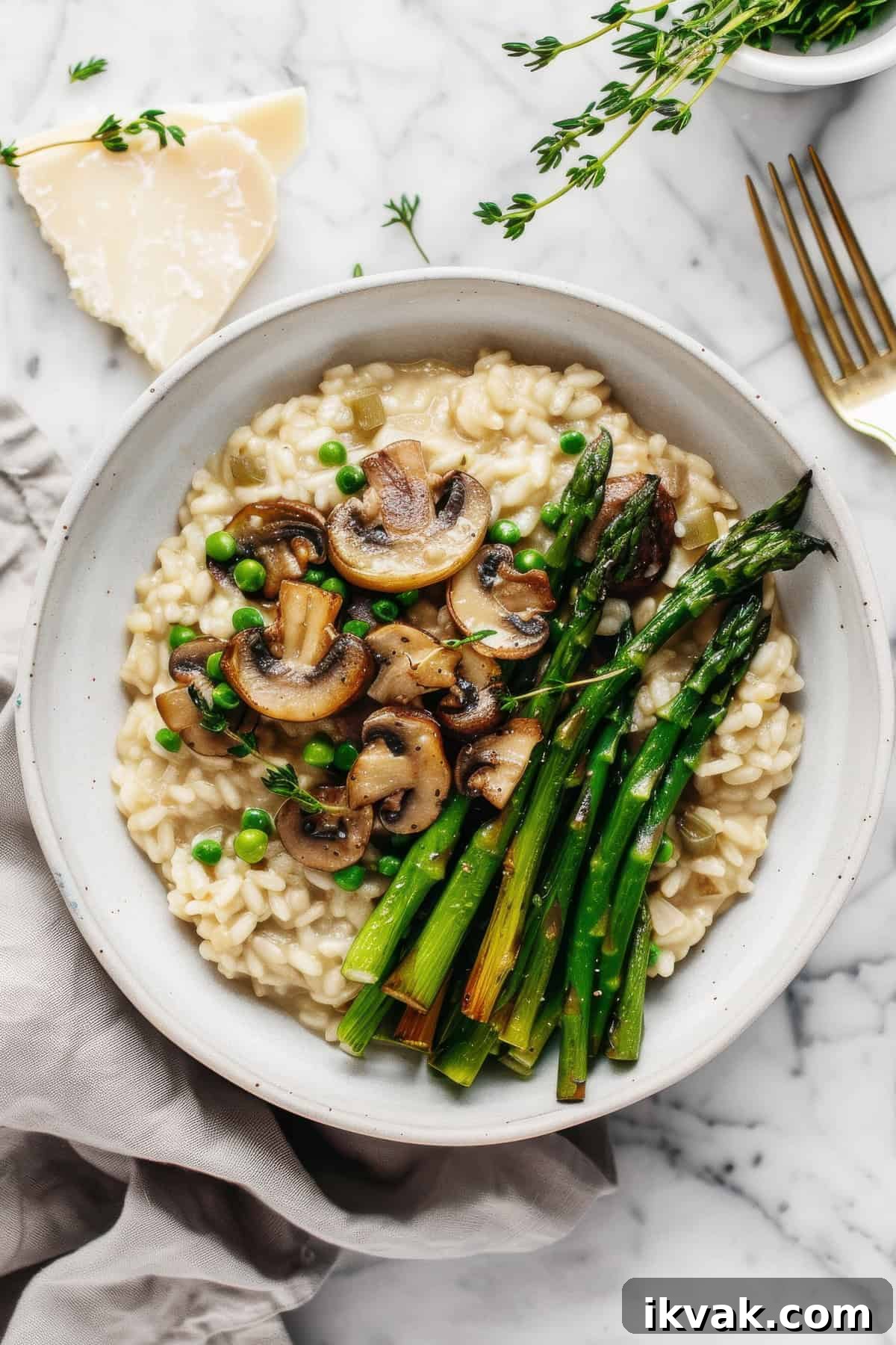 Creamy mushroom and asparagus risotto in a white bowl.