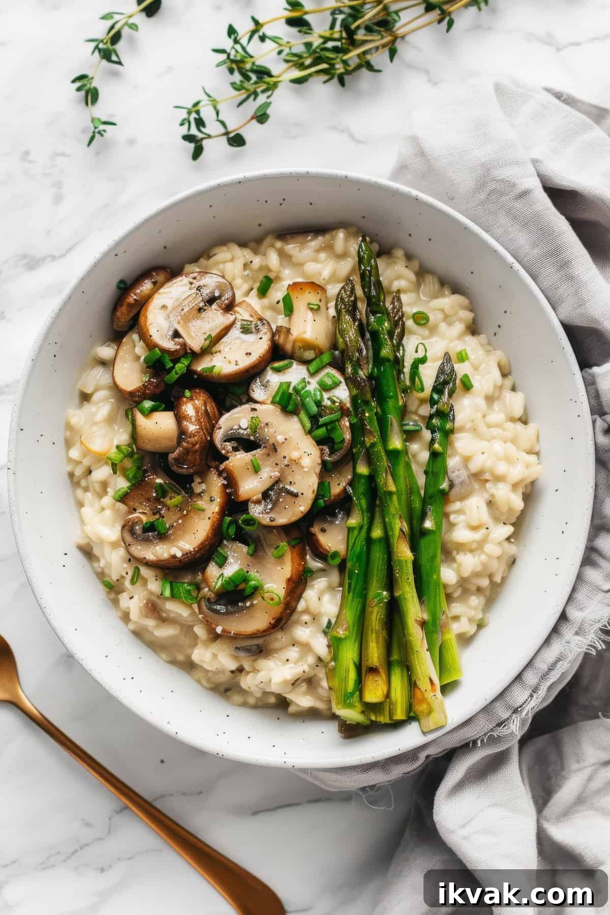 Creamy mushroom and asparagus risotto in a white bowl.
