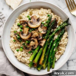 Creamy mushroom and asparagus risotto in a white bowl.