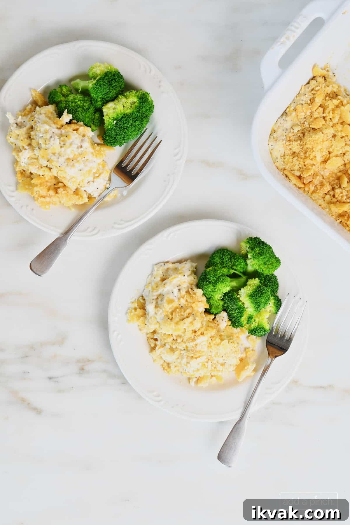 Two plates hold servings of poppy seed chicken casserole along with fresh steamed broccoli and forks.