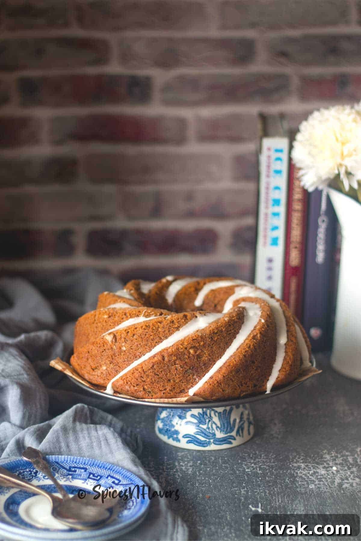 eggless yogurt coffee cake placed on a cake stand with some plates in the forefront ready to be served
