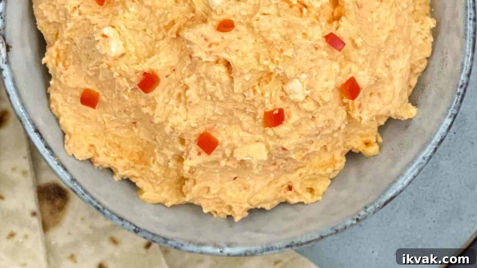 25 Creative Ways to Use Dip Recipes Beyond the Bowl 18 Spicy Greek feta dip in a bowl with pita bread by the side.