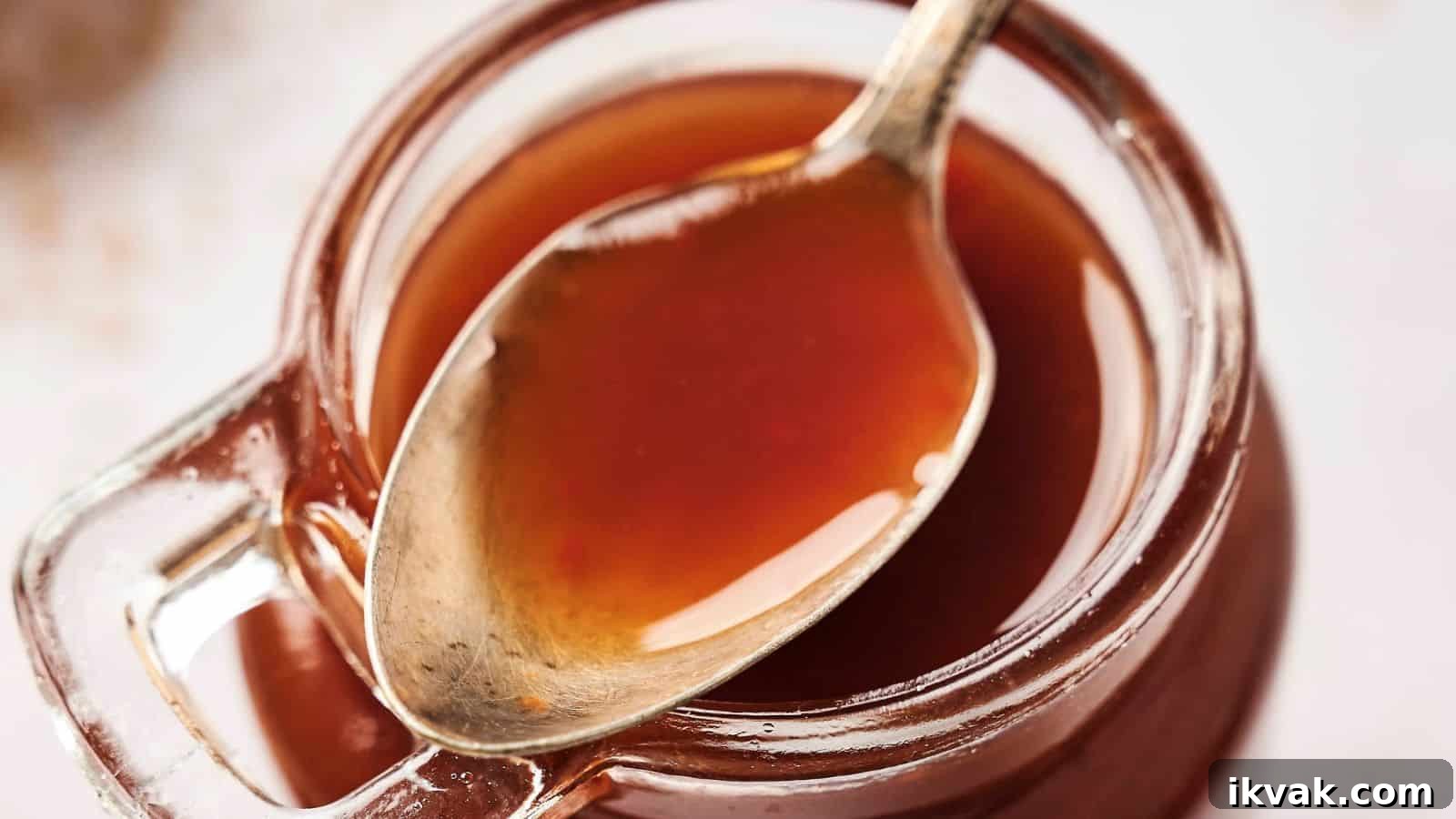 25 Creative Ways to Use Dip Recipes Beyond the Bowl 25 A spoon rests inside a glass jar filled with a thick, brown liquid.