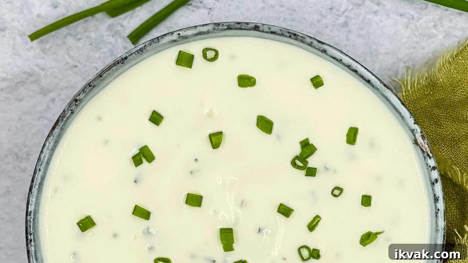 25 Creative Ways to Use Dip Recipes Beyond the Bowl 4 Sour cream and chives dressing in a bowl with chives and lemon around it.