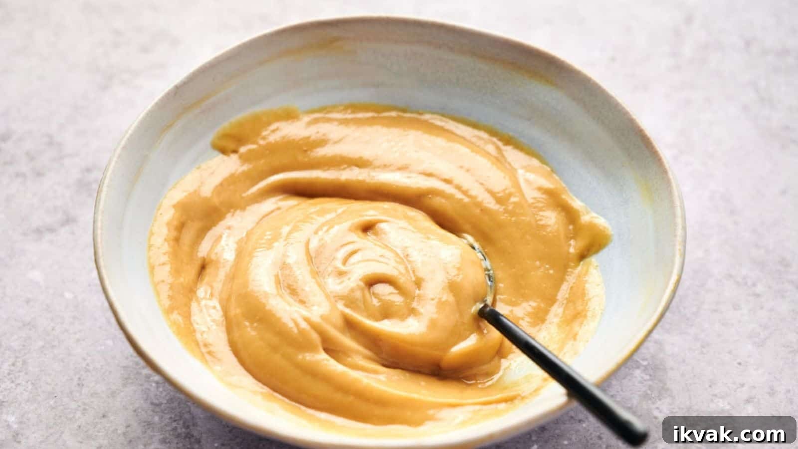 25 Creative Ways to Use Dip Recipes Beyond the Bowl 10 A bowl of smooth, creamy peanut butter with a hint of Chick-fil-A sauce and a spoon inside.