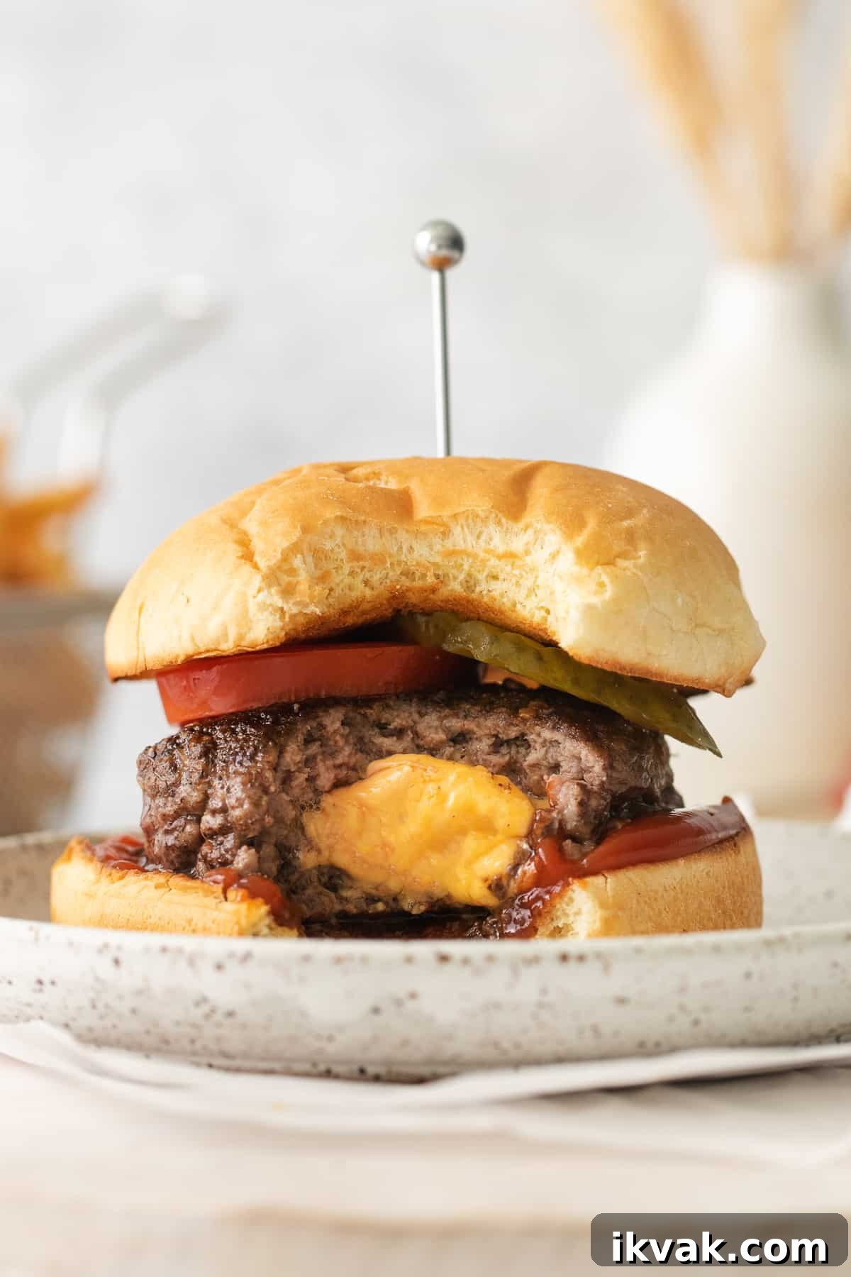 Juicy lucy burger wit ha bite taken out of it.