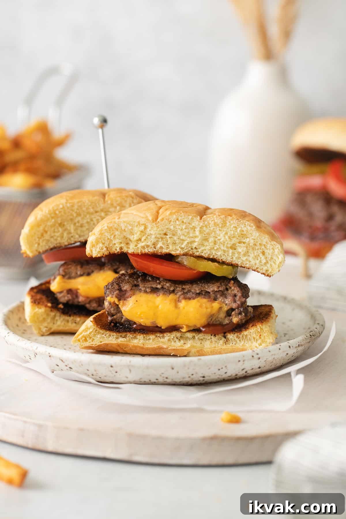 Jucy lucy burger cut in half on a plate.