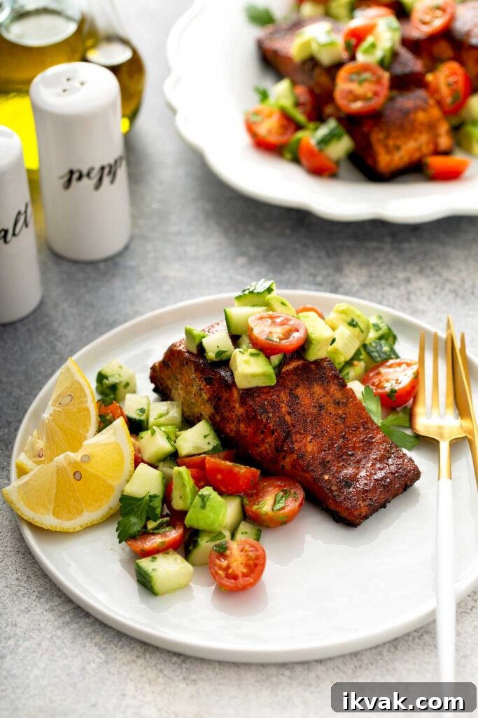 Blackened Salmon Recipe: Quick Cajun-Style Pan-Seared Fillets 13 Blackened salmon recipe with a fresh cucumber tomato and avocado salad served on a white plate