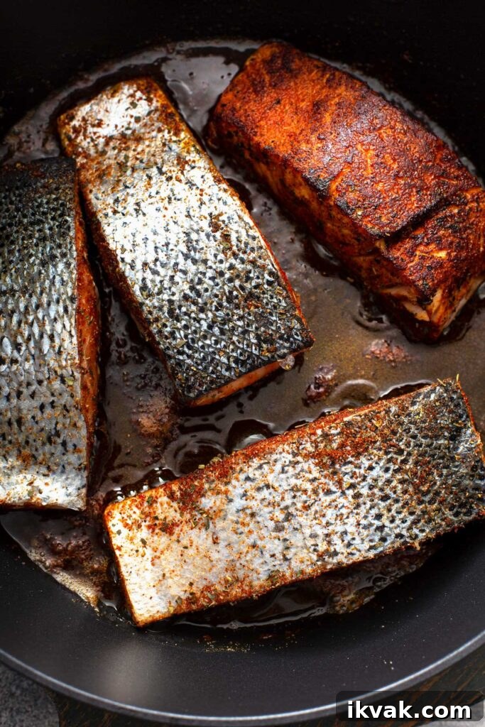 Blackened Salmon Recipe: Quick Cajun-Style Pan-Seared Fillets 10 Fish fillets pan searing in a cast iron skillet.