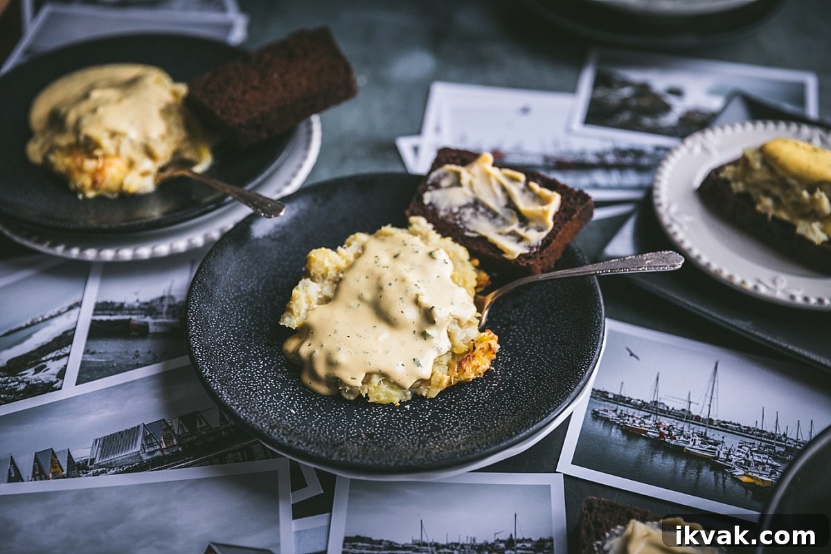 Plokkfiskur: Classic Icelandic Potato and Fish Stew 2 black plate of traditional plokkfiskur covered in quick bearnaise sauce with icelandic rye bread smothered with butter on side.