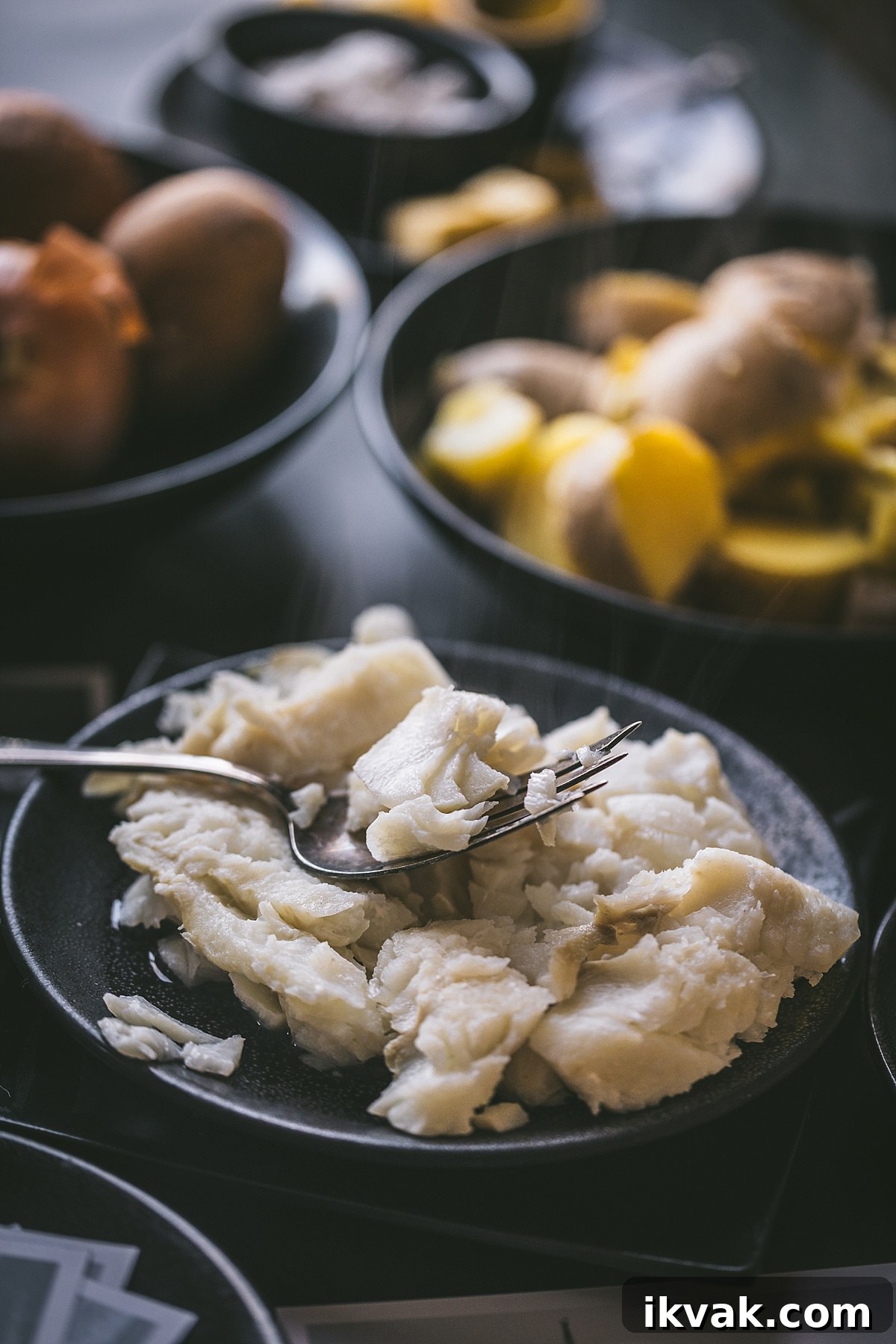 Plokkfiskur: Classic Icelandic Potato and Fish Stew 6 black plate of white poached cod flaked on a fork