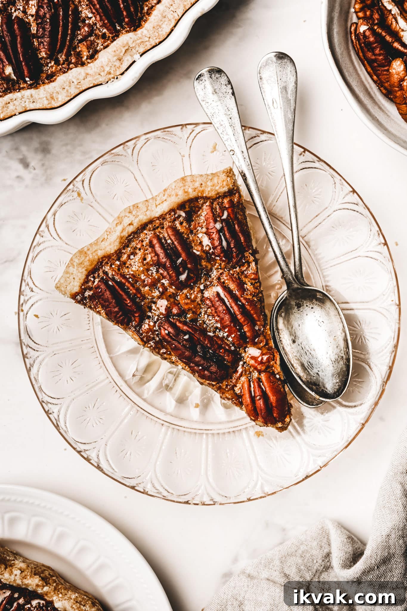 pecan pie slice in a plate with teaspoons