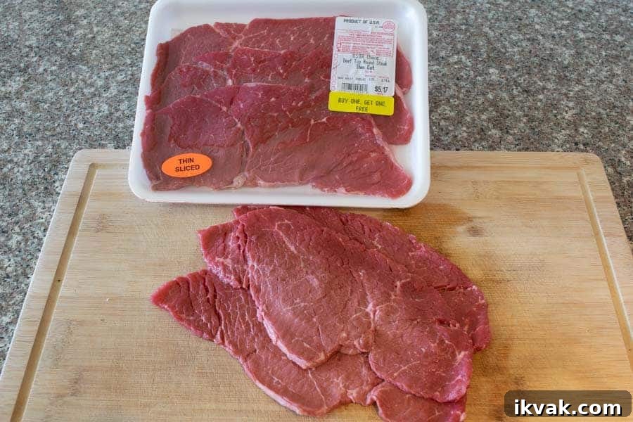 Thinly sliced beef top round on cutting board for jerky