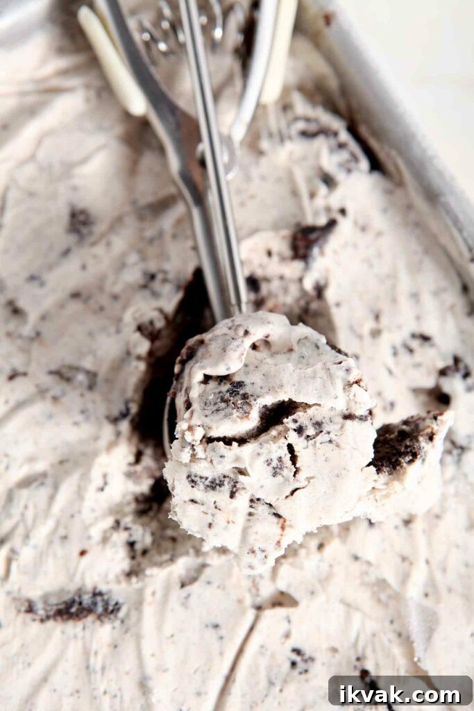 No Churn Fudge Brownie Ice Cream Recipe 4 An ice cream scoop runs through a pan of no churn ice cream