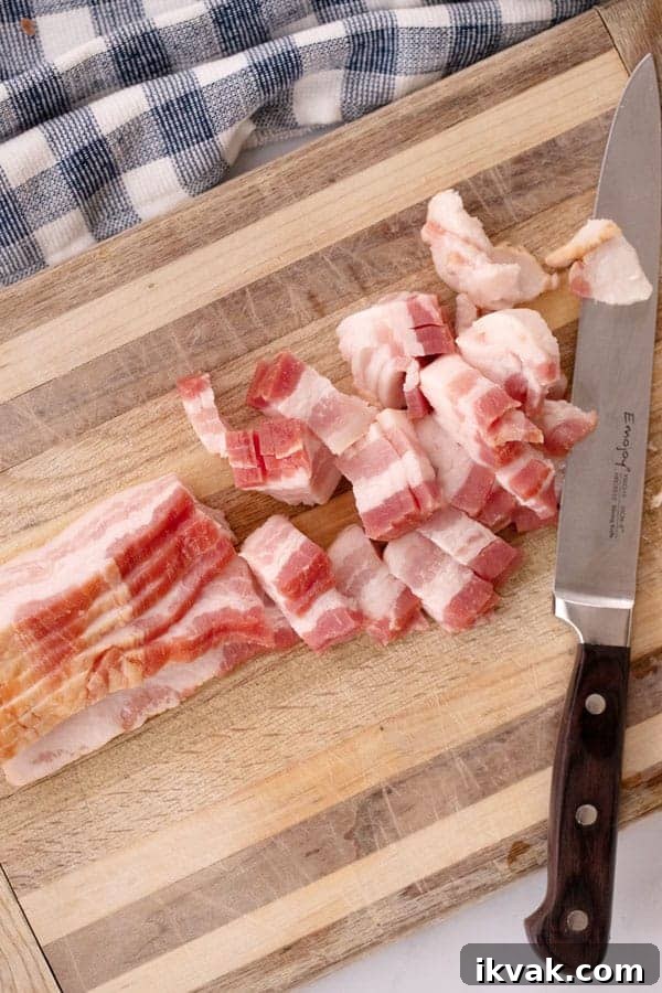 slices of bacon being cut on a cutting board with a knife to make bacon bits.